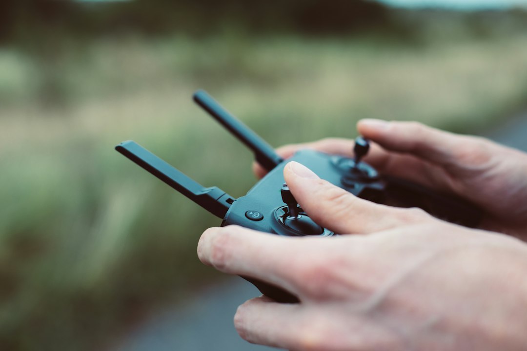 屋外でドローン送信機を操作する手元